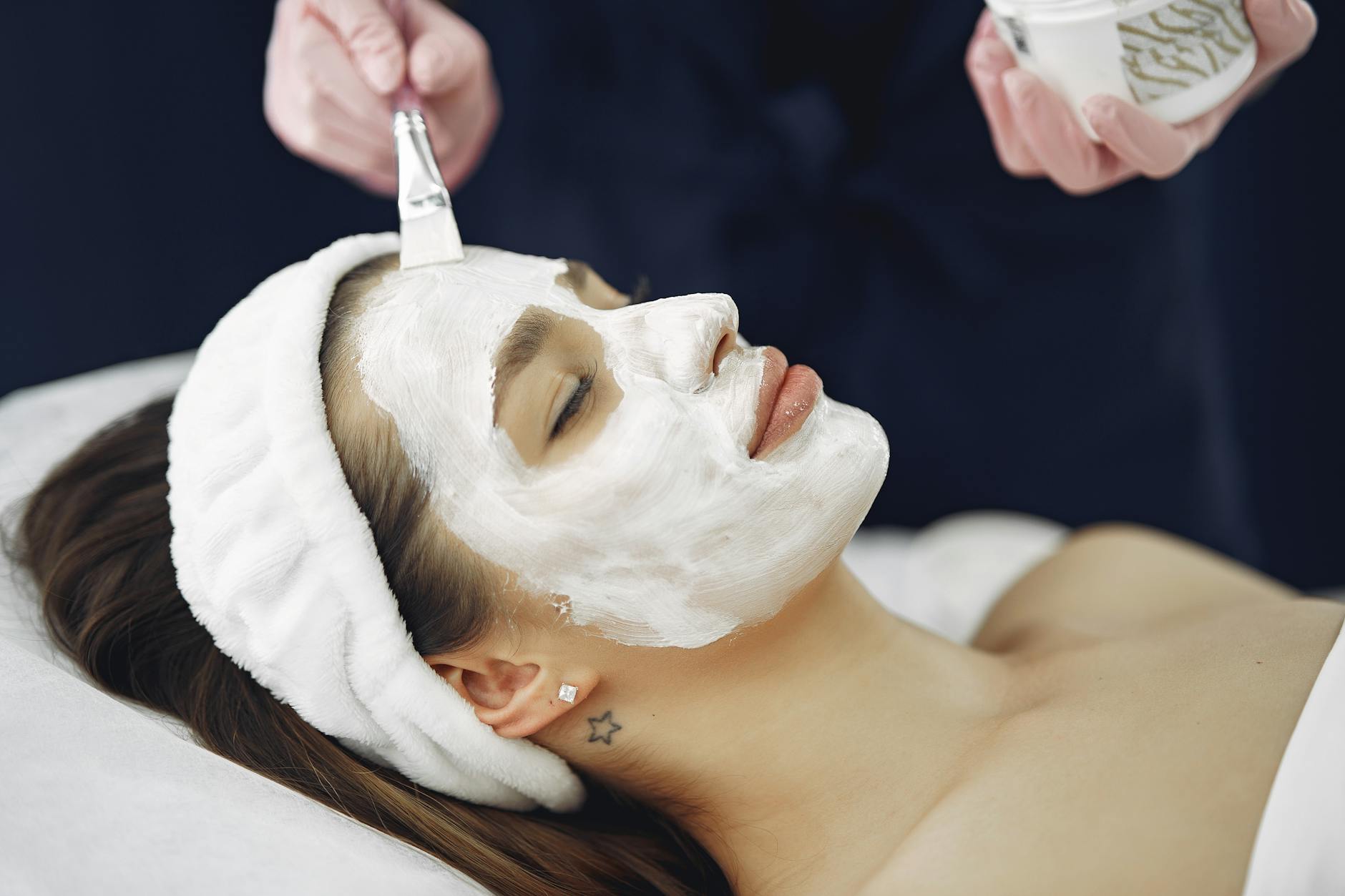 Kobieta w spa z nałożoną maseczką na twarzy podczas zabiegu relaksacyjnego